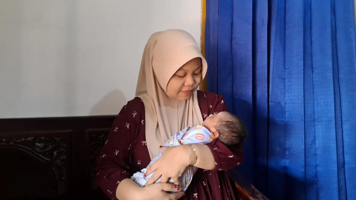 BERKESAN: Ilsiyah Hikmah Wardani menggendong anak pertamanya yang melahirkan dengan layanan JKN.