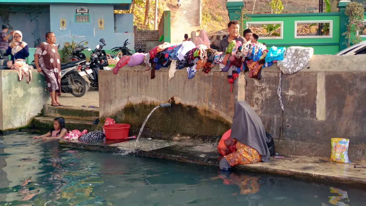 SANTAI: Warga menikmati air di Sumber Taman, Desa Waru Barat, Kecamatan Waru, Pamekasan, Sabtu (10/10).