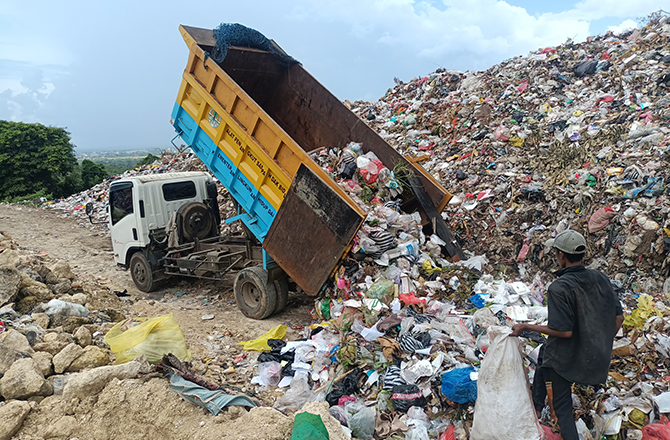 MENUMPUK: Sebuah truk menurunkan sampah di TPA yang berlokasi di Desa Torbang, Kecamatan Batuan, Sumenep, kemarin. (MOH. IQBAL/RadarMadura.id)