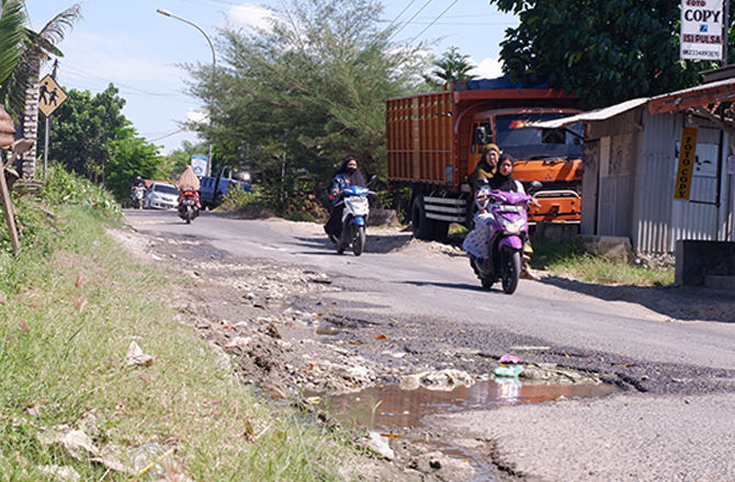 BUTUH PERBAIKAN: Pengendara motor menghindari jalan rusak di depan SMPN 1 Waru Pamekasan kemarin. (MOH. IQBAL AFGANI/RadarMadura.id)
