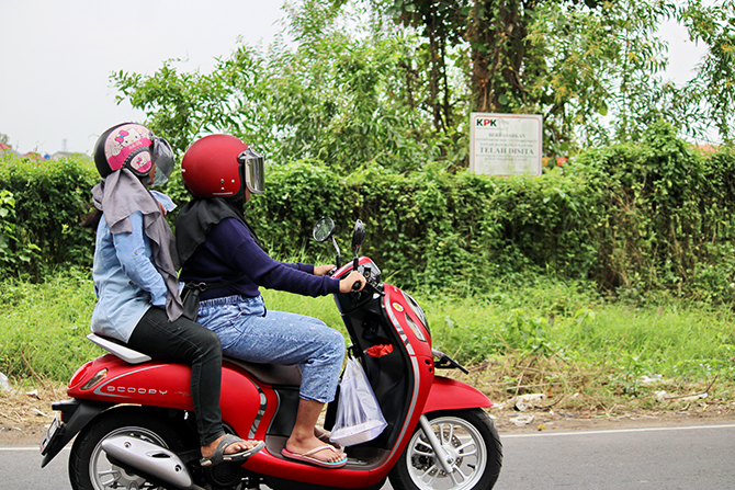 JADI MILIK DAERAH: Warga melintas di depan aset sitaan KPK yang saat ini diserahkan ke DPK di Jalan Halim Perdanakusuma kemarin. (VIVIN AGUSTIN HARTONO/RadarMadura.id)