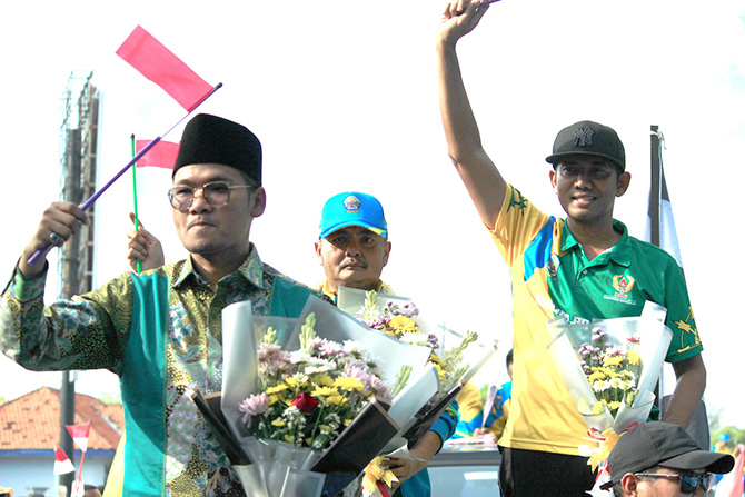 PENUH KEBAHAGIAAN: Bupati Bangkalan Abdul Latif Amin Imron, Ketum KONI Moch. Fauzan Ja’far, dan Kepala Dispora Akhmad Ahadiyan Hamid berada di atas jip menyapa masyarakat yang menyambut kedatangan kontingen porprov kemarin. (VIVIN AGUSTIN HARTONO/RadarMad