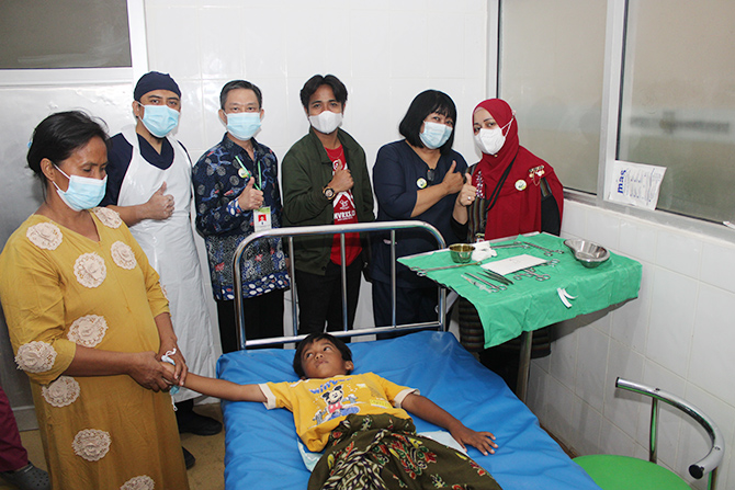 BERIKAN PELAYANAN GRATIS: Account Executive JPRM Taufikurrohman (tiga dari kanan) dan Direktur RSU Lukas Dr. dr Sugiharto, MBA, M.Kes. (mengenakan batik) bersama nakes setelah menyunat bocah kemarin. (VIVIN AGUSTIN HARTONO/RadarMadura.id)