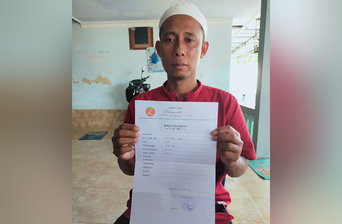 BERDUKA: Zahiruddin menunjukkan surat tanda kelahiran putranya dari RS Larasati, Pamekasan, kemarin. (ANIS BILLAH/RadarMadura.id)
