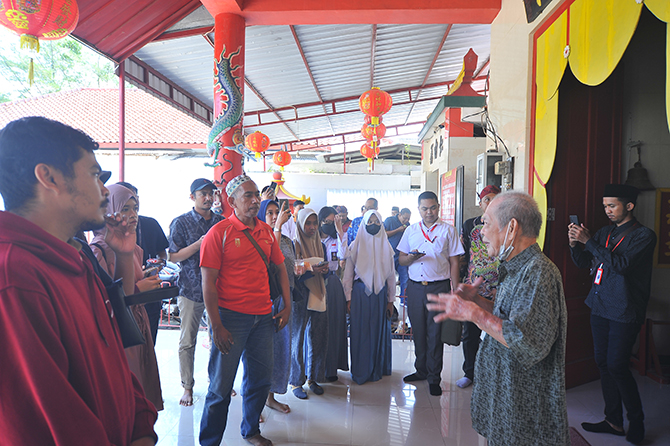 MENELUSURI SEJARAH: Pengelola Kelenteng Pao Sian Lin Kong Pabian, Sumenep, menjelaskan tentang sejarah kelenteng kepada pengunjung dalam Pabian Heritage. (RIDHO MARROTIN SUBASTIAN/RadarMadura.id)