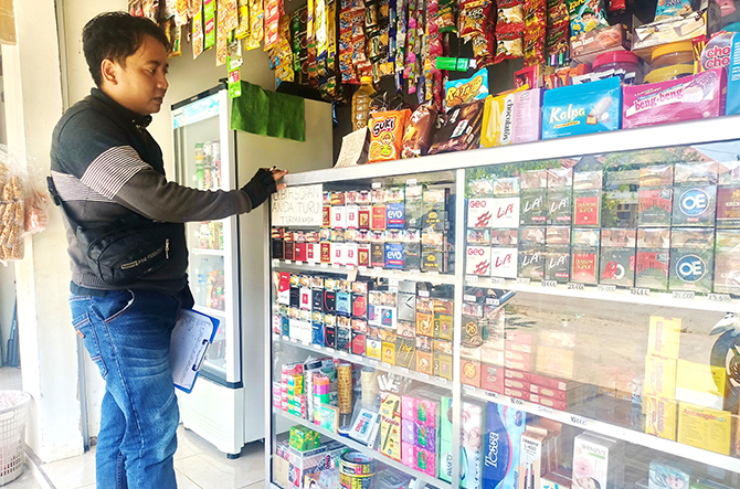 TERJUAL BEBAS: Warga belanja di toko kelontong yang juga menyediakan rokok bodong di Kecamatan Lenteng, Sumenep, kemarin. (MOH. IQBAL/RadarMadura.id)