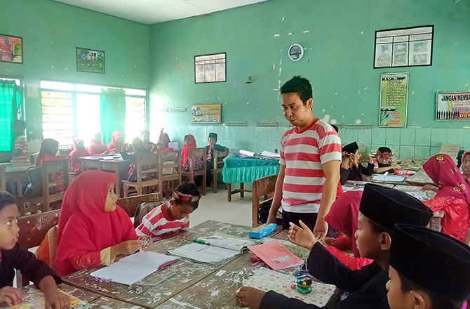 TELATEN: Husnul Yakin, saat memberi pelajaran di ruang kelas III-A dan B di SDN Lajing 2, Kecamatan Arosbaya, Bangkalan, kemarin. (FADIL/Radarmadura.id)