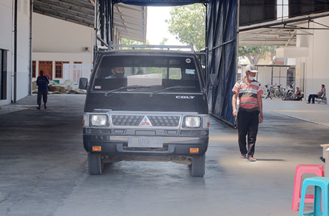 LALU-LALANG: Kendaraan pengangkut tembakau keluar dari Gudang PT Wijaya Sentosa Abadi, Jumat (16/9). (MOH. IQBAL AFGANI/RadarMadura.id)