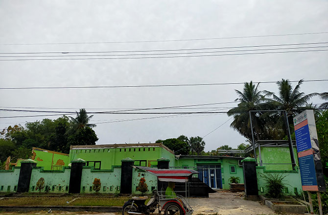 DIROMBAK: Tukang becak berada di depan gedung Puskesmas Pragaan yang akan dibangun melalui APBD 2022. (ANIS BILLAH/RadarMadura.id)