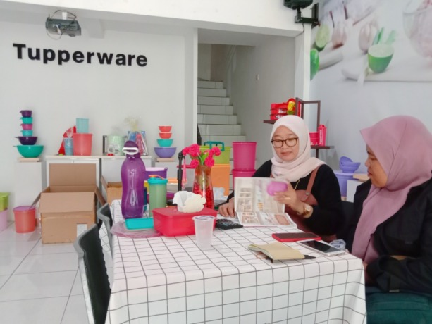 TUNJUKKAN KATALOG: Elite Director Tupperware Sumenep Poppy Verawati menunjukkan sejumlah produk di kantornya kemarin. (ERWIN MAULIDIN MASBACH/Radarmadura.id)