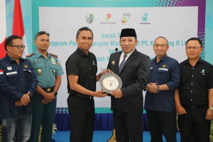 BERTERIMA KASIH: Bupati Sampang H. Slamet Junaidi mendapat kenang-kenangan dari President Director PCK2L Yuzaini MD Yusof didampingi Kepala SKK Migas Jabanusa Nurwahidi dan Danlanal Batuporon Letkol (P) Mahfud Effendi Kamis (10/11). (Zeinal Abidin/RadarMa