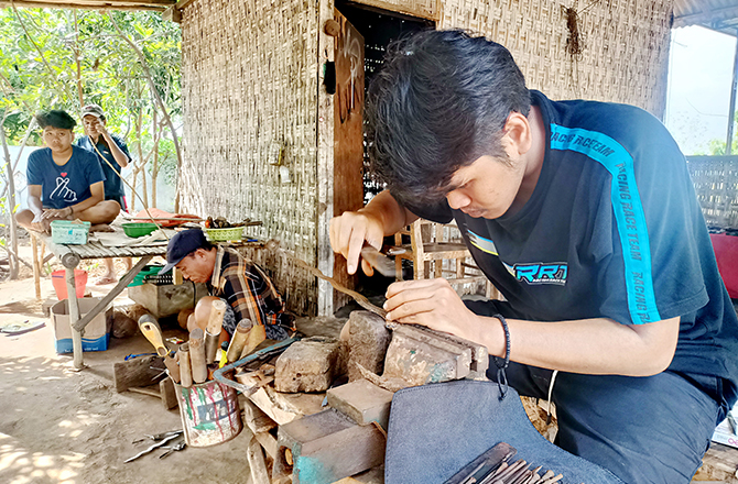 PRODUKSI: Perajin keris di Desa Aeng Tongtong membuat keris sebagai upaya pelestarian terhadap keberlangsungan desa wisata keris. (MOH. JUNAIDI/Radarmadura.id)