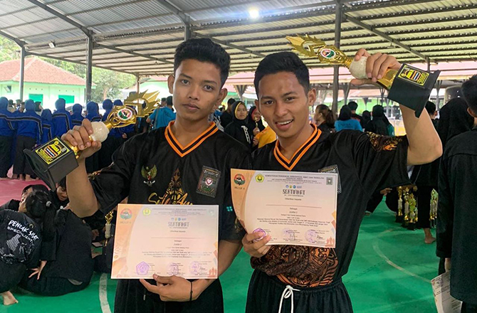 BEPRESTASI: Sofa Suyanto dan Rofiuddin memperlihatkan trofi dan sertifikat penghargaan setelah bertanding di Unej Cup VI 2022, Minggu (27/11). (SOFA UNTUK Radarmadura.id)