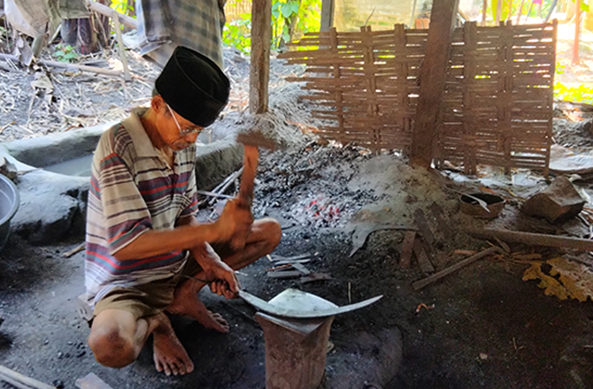 GIGIH: Hoped saat menempa besi untuk dijadikan celurit di rumahnya di Dusun Kolla, Desa Paterongan, Kecamatan Galis, Bangkalan, kemarin. (AYU LATIFAH/Radarmadura.id)
