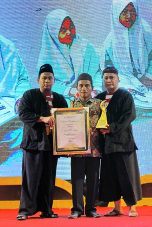 APRESIASI: Untung (tengah) mendapat penghargaan sebagai tokoh berjasa Madura Awards yang diserahkan dari Pemred JPRM Lukman Hakim AG (kiri) dan Direktur PT Madura Intermedia Pers Abdul Aziz di Gedung Bakorwil Pamekasan, Jumat (16/12) malam. (Vivin Agustin