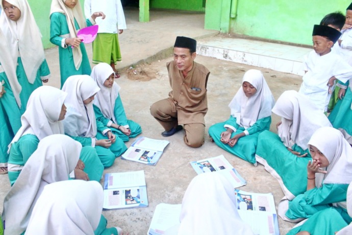 BERDEDIKASI: Pak Guru Untung mengajar siswa kelas VI MI Miftahul Ulum Batang-Batang, Sumenep, Rabu (14/12).( Muhammad Erwin Maulidin Maasbach untuk RadarMadura.id)