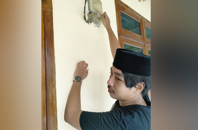 TINGKATKAN KEDISIPLINAN: Warga mengecek meteran listrik di rumahnya kemarin. (MOH. IQBAL AFGANI/Radarmadura.id)