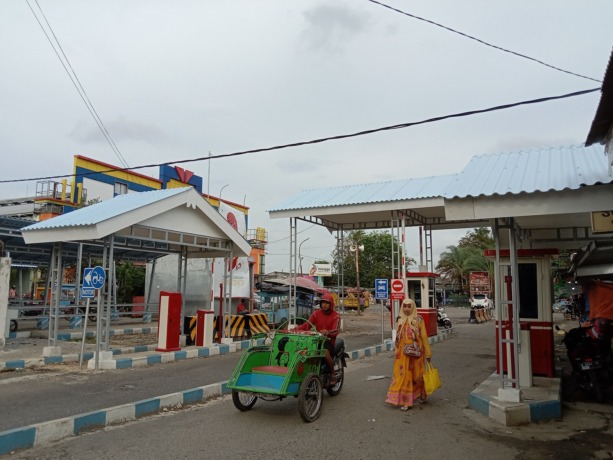 BELUM BEROPERASI: Pengunjung keluar dari Pasar Anom Baru Sumenep melewati pintu portal yang belum berfungsi, Selasa (7/2). (MUHAMMAD ERWIN MAULIDIN M/JPRM)