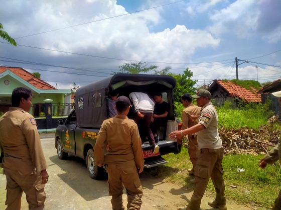 TERTANGKAP BASAH: Lima siswa dinaikkan ke mobil patroli satpol PP di depan warung kopi Tia, Jalan Merpati, Kelurahan Gunung Sekar, Sampang, Rabu (22/2). (FADIL/JPRM)