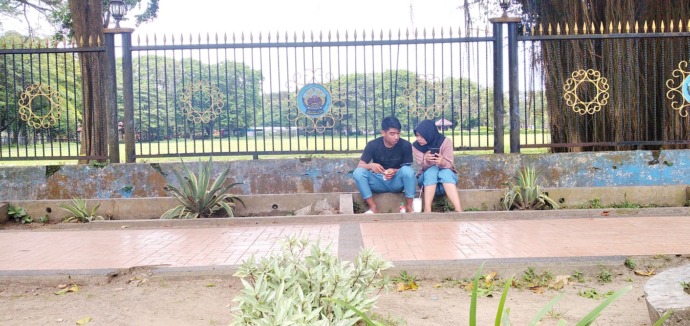 BUTUH PENGAWASAN: Pemuda sedang bermain gatget di alun-alun Kota Bangkalan Senin (27/2). (UBAIDILLAHIR RA’IE/JPRM)