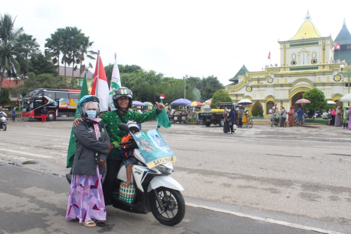 BERSEMANGAT: Achmad Fauzan dan Mutmainnah beserta kedua buah hatinya berpose di depan Masjid Jamik Sumenep dalam perjalanan menuju Harlah 1 Abad NU Senin (6/2). (MUHAMMAD ERWIN MAULIDIN M/JPRM)