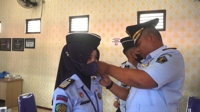 BERKOMITMEN: Karutan Kelas II-B Sumenep Ridwan Susilo memasang tanda kenaikan pangkat kepada para petugas di kantornya, Selasa (21/3). (RUTAN SUMENEP UNTUK JPRM)