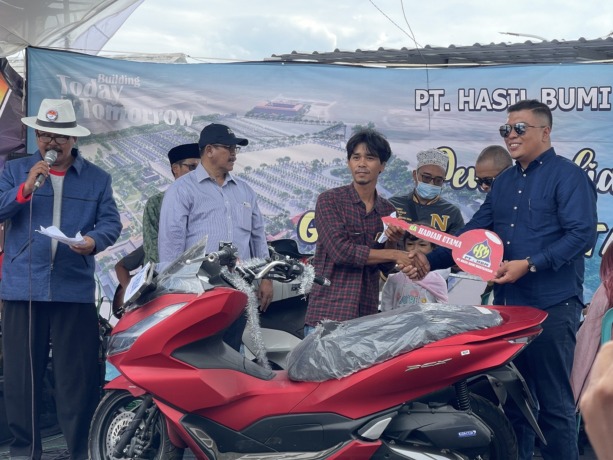 BERTABUR HADIAH: Direktur PT HBM Yahya Assegaf menyerahkan hadiah utama kepada pemenang disaksikan oleh Plt Bupati Bangkalan Mohni, Sabtu (4/3). (DARUL HAKIM/JPRM)