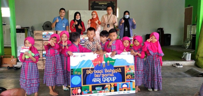 PEDULI: Pemimpin Cabang BRI Bangkalan Mohammad Arief Prabowo (dua dari kanan) dan pengurus Yayasan Sosial Darun Najah, Kecamatan Kamal, berfoto bersama dengan anak yatim piatu, Rabu (12/4). (UBAIDILLAHIR RA’IE/JPRM)
