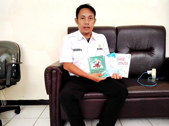 EDUKATIF: Kepala SMAN 4 Bangkalan Hendrik Dewantara menunjukkan tiga karya bukunya, Rabu (3/5). (JUPRI/JPRM)