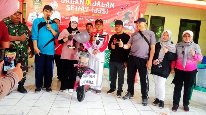 RANGKAIAN ROKAT DESA: Kades Dungkek Ach. Jumahri, S.E. menyerahkan hadiah utama JJS bersama bupati Sumenep, Minggu (21/5).