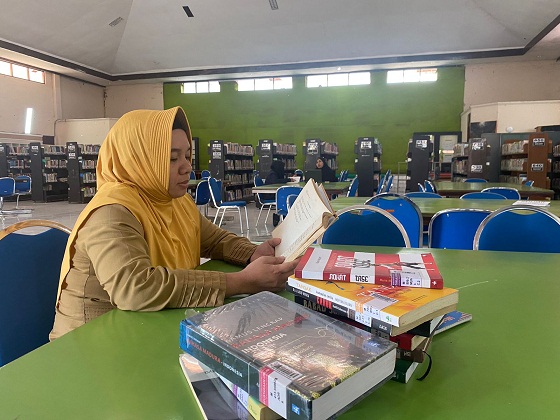 MINIM: Mahasiswa mengambil buku Kamus Bahasa Madura di Perpsutakaan Dinas Perpustakaan dan Kearsipan Pamekasan,  Selasa (16/5). (MOH. JUNAIDI/JPRM)
