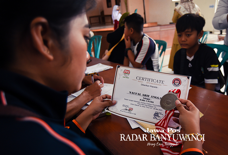 VERIFIKASI: Panitia PPDB SMPN 1 Giri mengecek piagam penghargaan milik pendaftar. Peserta PPDB menjalani uji petik olahraga hoki.