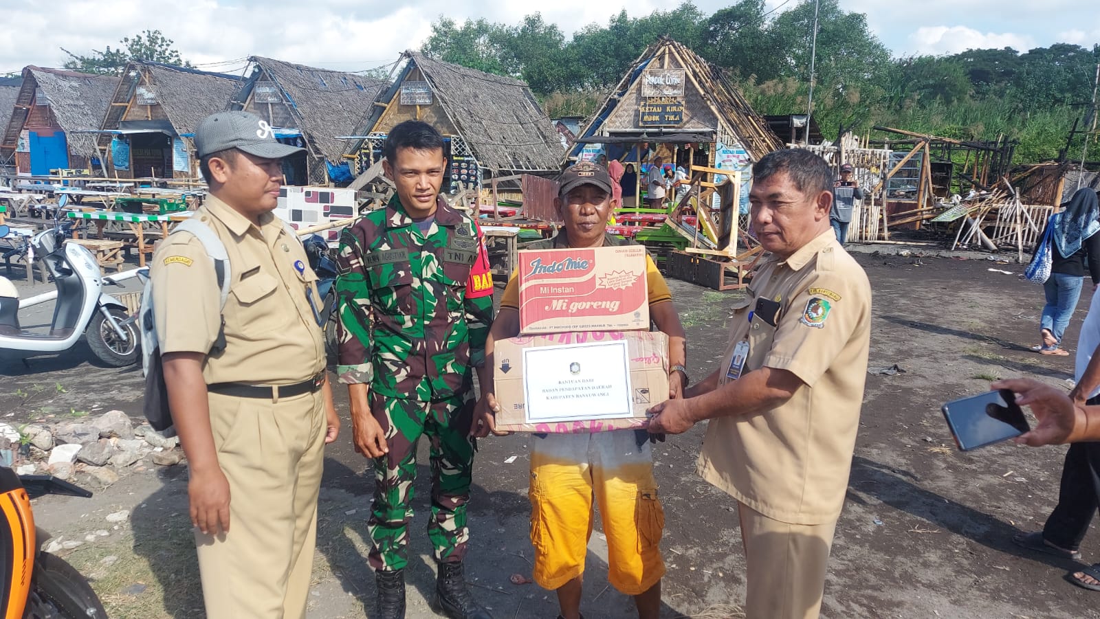 BANTUAN: Bapenda Banyuwangi menyerahkan sembako kepada korban kebakaran di Pantai Ancol, Kelurahan Lateng.