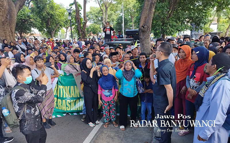 TENANGKAN WARGA: Ahmad Rifai, kuasa hukum Mulyadi, Suwarno, dan Untung menjelaskan hasil sidang di hadapan warga yang berunjuk rasa di depan PN Banyuwangi kemarin.