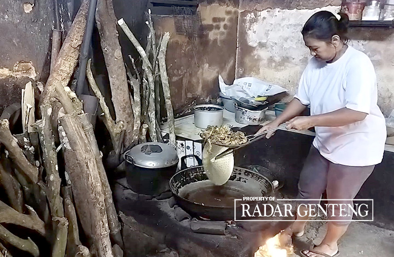 PAKAI TUNGKU: Wagiyem memasak di warungnya Dusun Petahunan, Desa Jajag, Kecamatan Gambiran menggunakan kayu bakar, Jumat (16/6).