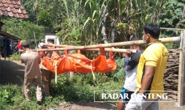 MENGENASKAN: Warga dan perangkat desa mengevakuasi jenazah Aris dengan membawa ke rumahnya di Dusun Krajan Baru, Desa Wonosobo, Kecamatan Srono Selasa (20/6).