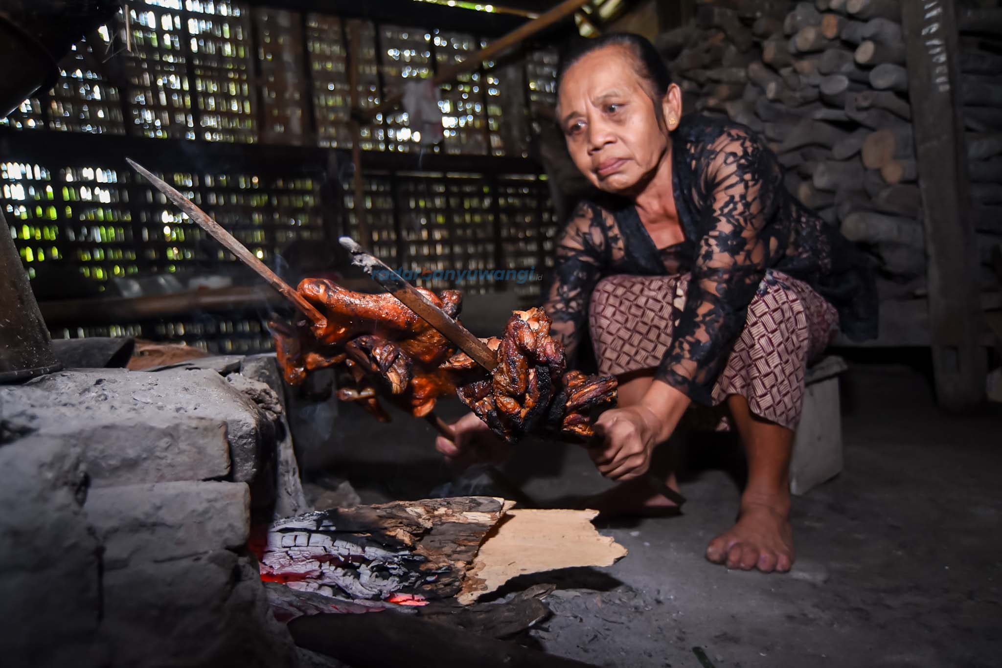 mbah iswanah sedang mambakar dua peteteng petek untuk menyiapkan selametan tumpeng sewu di kemiren