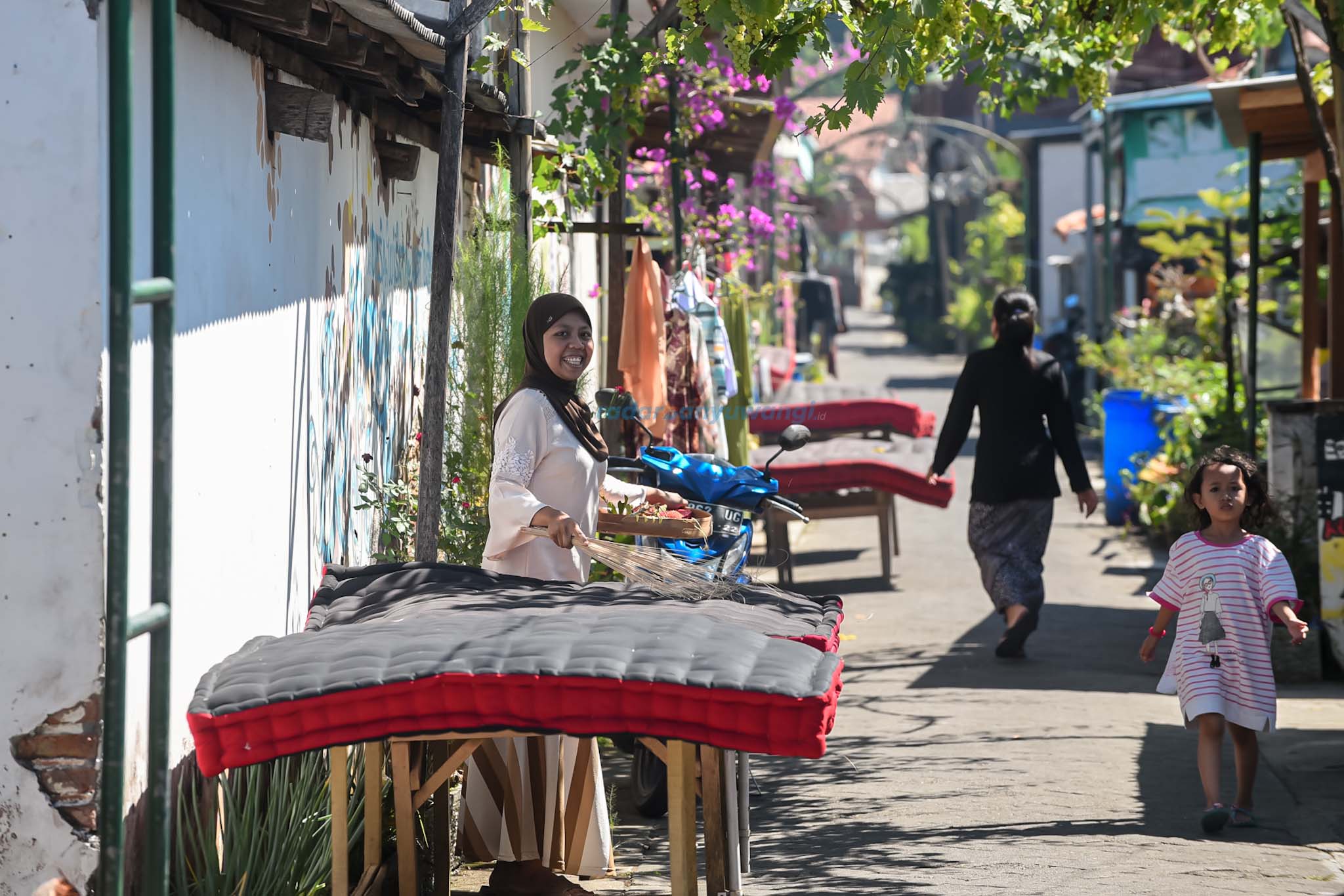 Warga suku Osing membersihkan kasur yang dijemur di depan rumahnya, Desa wisata Adat Kemiren. Tradisi ini dilakukan awal bulan dhulhizah untuk bersih desa
