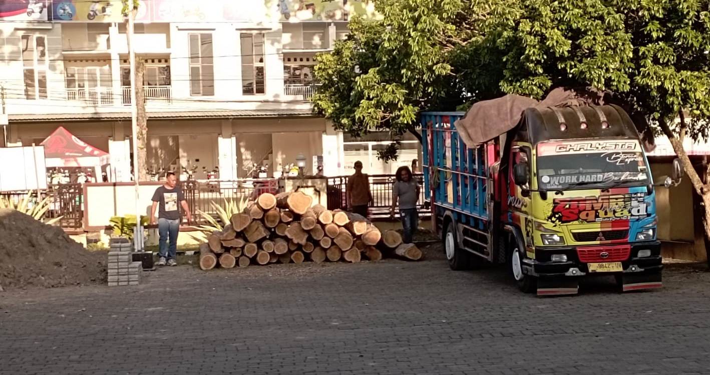 DITUMPUK: BB berupa 40 glondong kayu jati yang diduga illegal dan truk yang mengangkutnya diamankan di Mapolsek Cluring, Jumat (23/6)