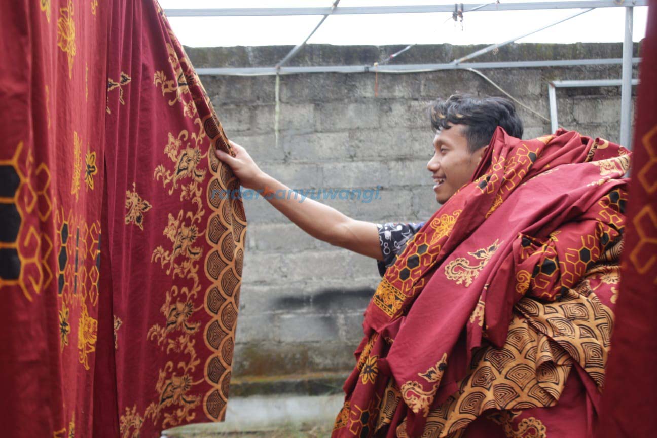 ALAMI: Perajin mengangkat jemuran batik yang sudah jadi di Desa Tampo, Kecamatan Cluring.