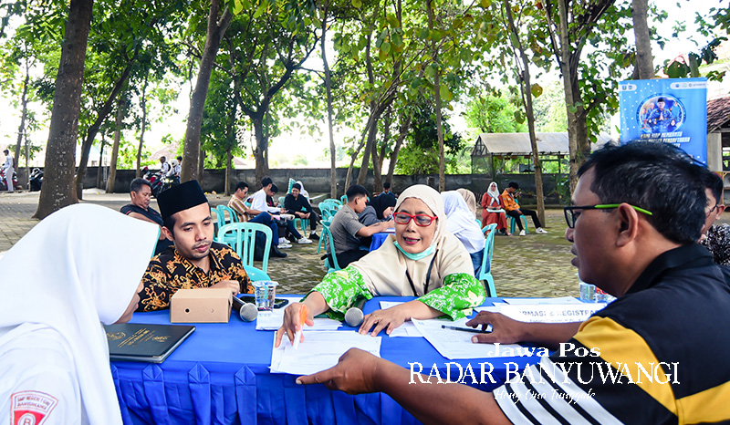 BERI PELAYANAN: Panitia PPDB SMKN 1 Glagah membantu calon pendaftar mengambil PIN untuk keperluan pendaftaran peserta didik baru.