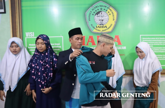 LEPAS: Rektor IAI Darussalam, Blokagung, Banyuwangi, Dr H Ahmad Munib Syafaat mengenakan jaket almamater pada salah satu mahasiswa yang akan mengikuti KKPK di Thailand, Minggu (2/7).