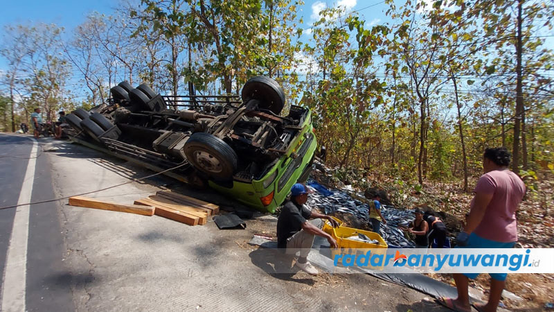 TRUK GULING: Anggota Kanitlaka Polres Situbondo dibantu oleh warga memilih ikan tongkol yang tumpah di Jalan Raya Baluran, Desa Sumberwaru, Kecamatan Banyuputih, Kamis (6/7).