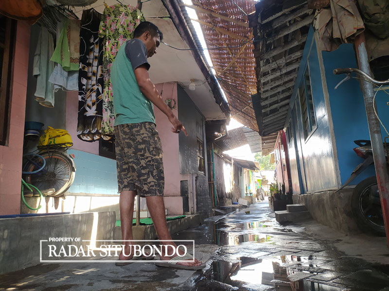 TERCEMAR: Lutfi menunjukkan sisa genangan air sungai yang ada di halaman rumahnya, di Dusun krajan, Desa Gudang, Kecamatan Asembagus. Air tersebut mengeluarkaan aroma bau menyengat.