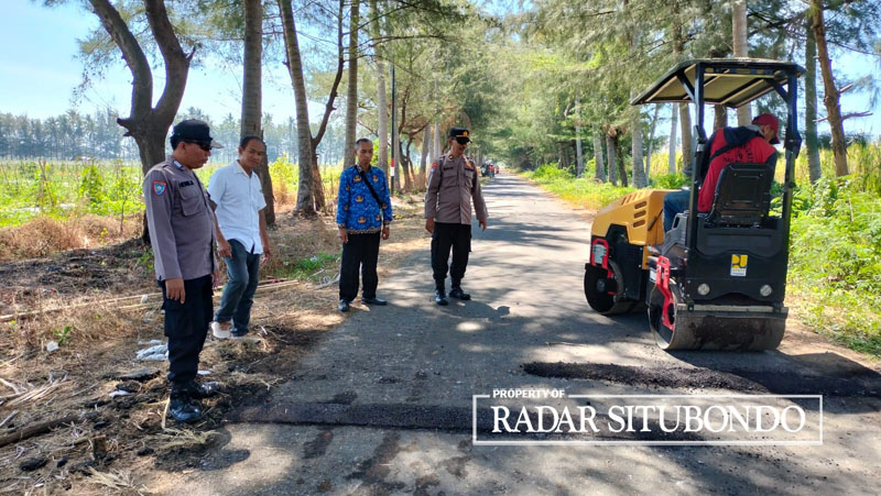 RAWAN BALAP LIAR: Anggota Polsek Asembagus bersama Dinas PUPP Situbondo memasang marka kejut di  Jalan Banongan, Desa Wringinanom, Kecamatan Asembagus, Selasa (18/7).