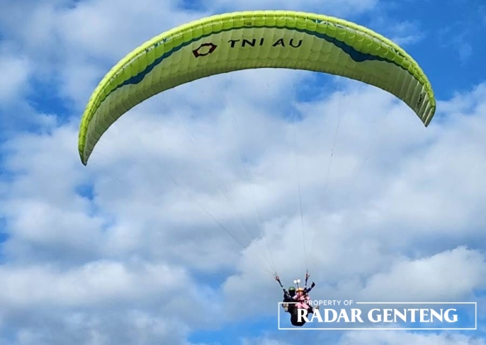 TERBANG: Salah satu atlet paralayang saat beraksi di venue Gunung Menyan petak 33 D, RPH Malangsari, BKPH Genteng, Perhutani KPH Banyuwangi Selatan, Desa Kalibaru Wetan, Kecamatan Kalibaru