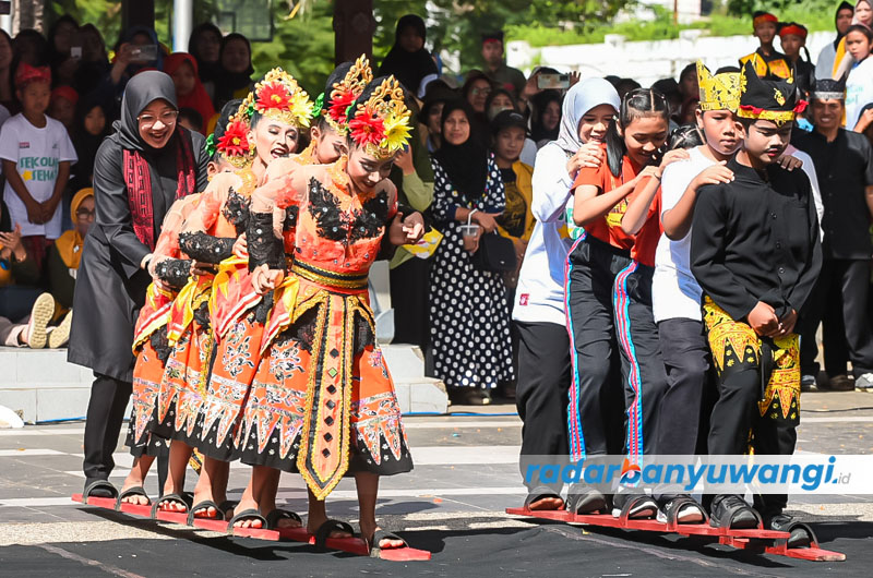 ADU KOMPAK: Bupati Ipuk Fiestiandani Anas menjajal bakiak panjang bersama anak-anak pada Festival Permainan Anak Tradisional di Lapangan Blambangan Banyuwangi, Sabtu (22/7).