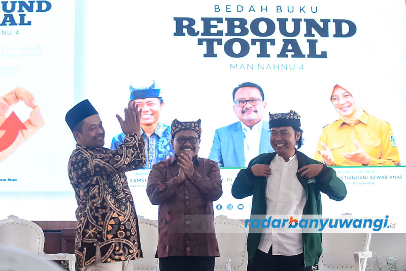ANGGOTA KEHORMATAN ISNU: Samsudin Adlawi mengenakan jaket ISNU pemberian dari Ketua ISNU Banyuwangi Abdul Azis (kiri) disaksikan ketua PW ISNU Jatim Mas&rsquo;ud Said (tengah).