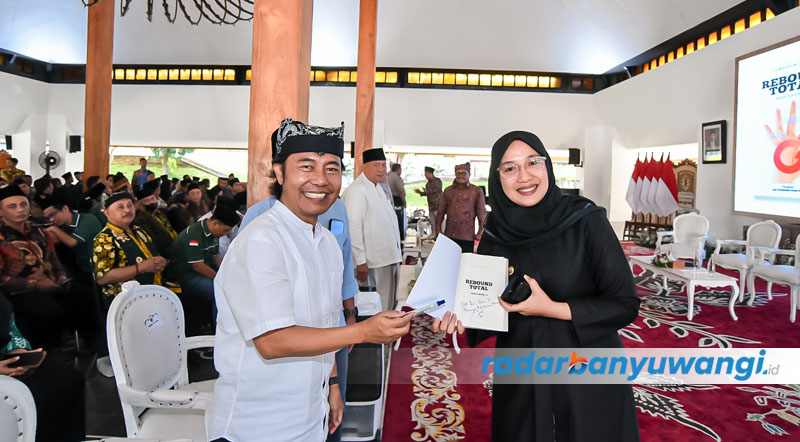 DIKOLEKSI BUPATI: Samsudin Adlawi menyerahkan buku Rebound Total kepada Bupati Ipuk Fiestiandani Azwar Anas dalam bedah buku di Pendapa Sabha Swagata Blambangan, Kamis (27/7).