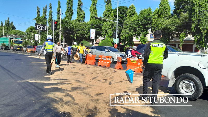 ANTISIPASI KECELAKAAN: Anggota Satlantas Polres Situbondo menaburkan serbuk kayu di perempatan lampu merah Alun-alun Kota Situbondo, Jumat (4/8).